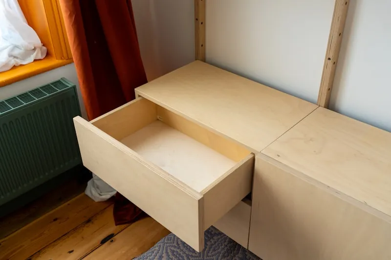 Open birch plywood drawer in a wall-hung cabinet, with the plywood edge layers visible